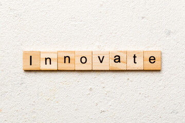 INNOVATE word written on wood block. INNOVATE text on cement table for your desing, concept
