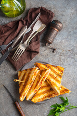 Classic club sandwich on a plate. The sandwich filling includes ham, cheese, lettuce, tomato slices
