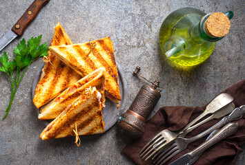 Classic club sandwich on a plate. The sandwich filling includes ham, cheese, lettuce, tomato slices