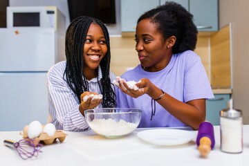 happy african american couple in love making a cake at home