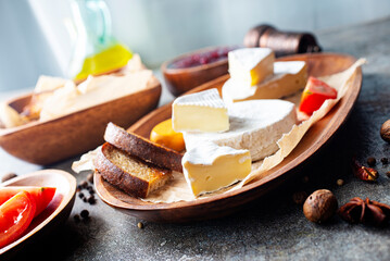 Camembert cheese with figs, raspberry jam. Round brie or camambert cheese on cutting board