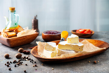 Camembert cheese with figs, raspberry jam. Round brie or camambert cheese on cutting board