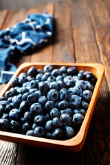 Freshly picked blueberries in wooden bowl. Juicy and fresh blueberries