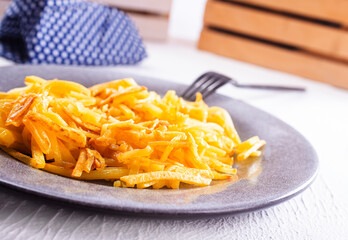 Homemade Baked Potato Fries with oil and rosemary on white wooden board