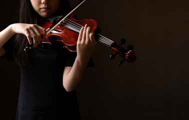 Teen playing violin in formal wear