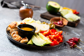 Cobb salad with sauce. Traditional american dish made of salad leaves, avocado, cherry tomatoes, fried chicken and spices
