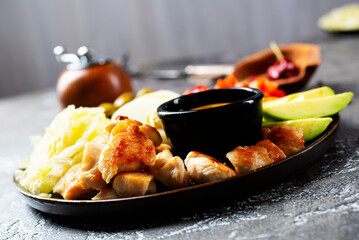 Cobb salad with sauce. Traditional american dish made of salad leaves, avocado, cherry tomatoes, fried chicken and spices