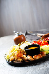 Cobb salad with sauce. Traditional american dish made of salad leaves, avocado, cherry tomatoes, fried chicken and spices