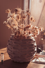 backlited flowers in vase on the table in sunset time