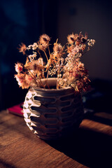 backlited flowers in vase on the table in sunset time