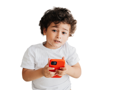 Portrait from top of handsome curly Brazilian curly boy  holding phone looking at camera over transparent background. Domestic leisure, children using gadgets. Handsome caucasian kid spends time home. - Powered by Adobe