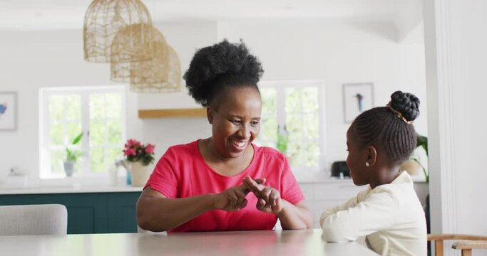 Video of smiling african american grandmohter using sign language with her granddaughter, copy space