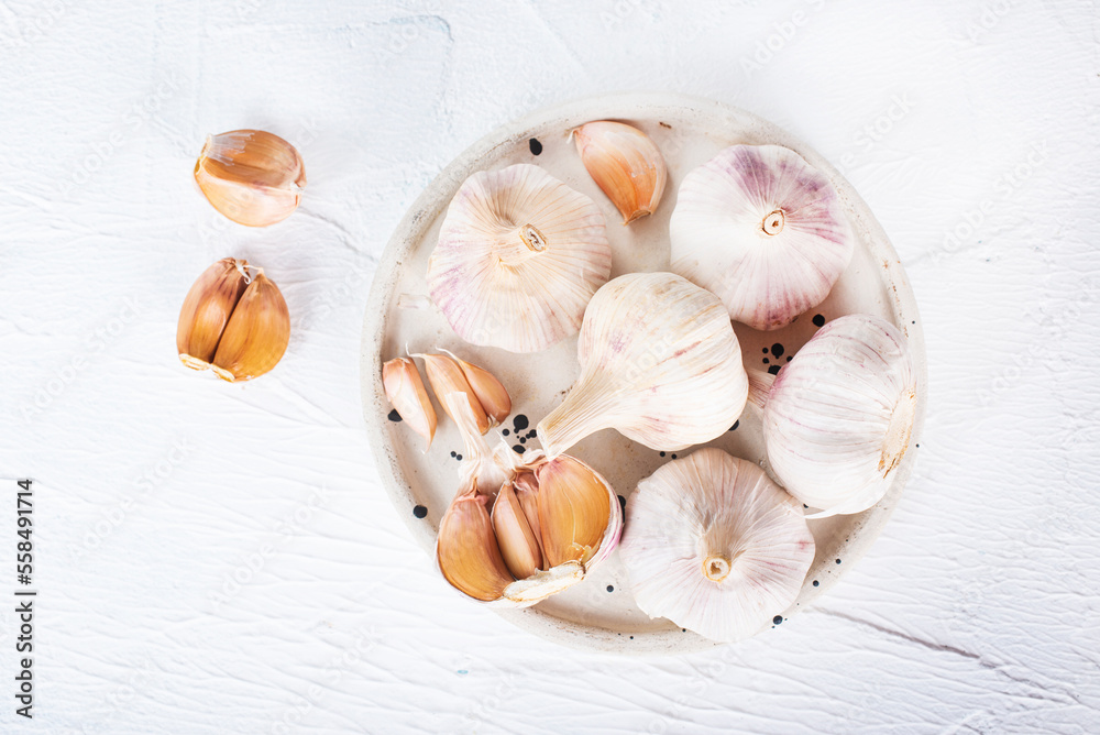 Poster garlic cloves and bulb in vintage claim bowl.