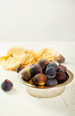 A few figs in a bowl on an old light background.