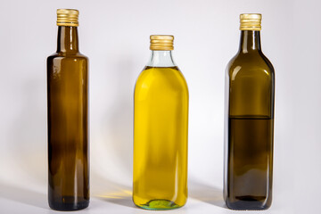 Three different glass bottles with olive oil.