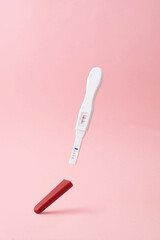 Positive pregnancy test on pink background