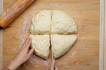 Overhead view of cutting dough in quarters.