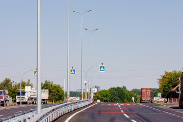 New asphalt road with markings and road signs in the sun's rays