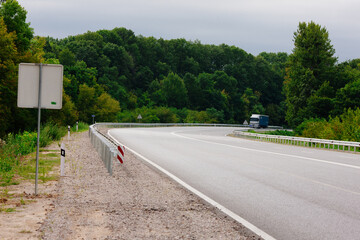 New asphalt road with markings and road signs in the sun's rays