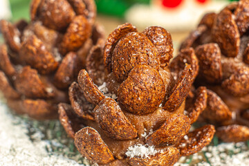 Dark Chocolate realistic edible Pinecone cake sprinkled with powdered sugar and coconut flour as snow. Cool-looking Christmas cookies on plate macro.