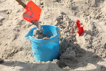 blue bucket and shovel in the sand at the beach