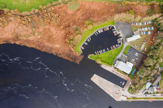 Aerial top down view on a small pier and boat storage by a river. Yacht club by a lake.