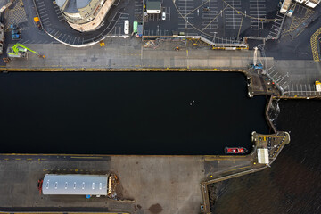Aerial top view on a port with commercial and private ships and yachts, Heavy cargo tracks with good waiting for unload, Concept international trade.