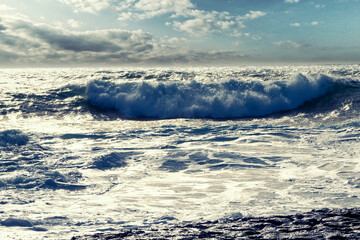 Powerful waves in the ocean and rough stone coast line. West of Ireland. Cloudy sky. Irish landscape scene. Power of nature concept.