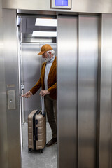 Man with suitcase using elevator on train station © Budimir Jevtic