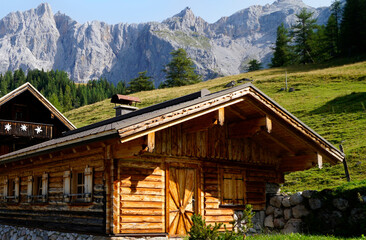 Fototapeta na wymiar rustic wooden alpine cabins by the foot of the Dachstein mountain in the alpine village Neustatt Alm or Neustattalm in the Austrian Alps of the Schladming-Dachstein region (Steiermark, Austria)