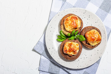 Baked stuffed mushroom caps ready for eating. Champignons, spices, vegetables, cheese
