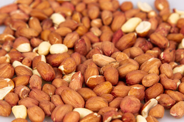 A lot of unpeeled peanuts isolated on a white background. Clipping path. Full depth of field. background image.