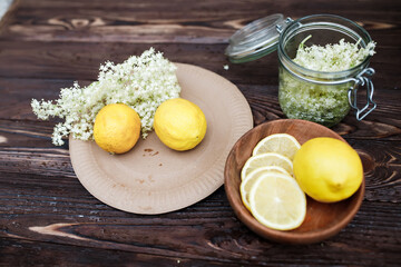 Ingredients for making a drink of elderberry and lemons. Lemon slices and fresh elderberry inflorescences ready for preservation for the winter.