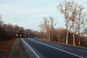 Fototapeta premium New asphalt road with markings and road signs in the sun's rays