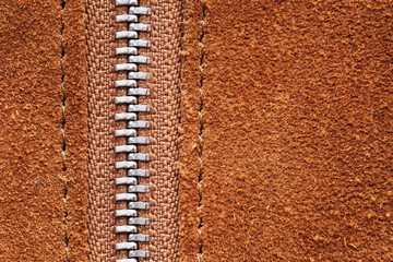 Metal zipper. Brown suede fabric. Empty copy space textile background. Thread sew closeup fabric.