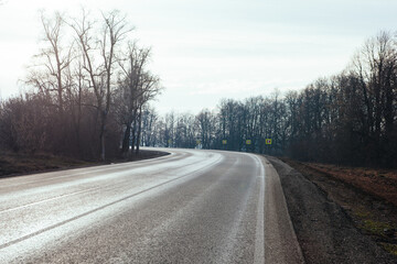 New asphalt road with markings and road signs in the sun's rays