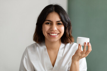 Headshot of beautiful woman using new cosmetic at home