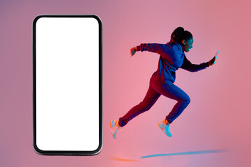 Active black lady exercising, running with cellphone next to giant smartphone with blank white screen, mockup