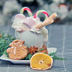 marshleylow, multi-colored candy cane, coconut tubes and whipped cream in a white mug with hot chocolate. The addition is gingerbread cookies in the form of a snowman. Also in the design used a branch