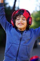 Stylish teen boy listening music in headphones and social media posing.