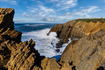 Sea waves crash against stones in beautiful white splashes. Seascape. Panoramic view of the seashore