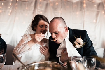 the bride and groom are fed soup during the wedding reception
