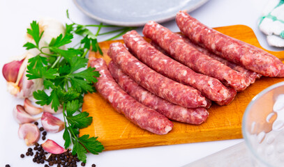Fototapeta premium Traditional Catalan raw pork sausage longaniza ready for grilling on wooden board