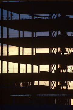 Silhouette of worker on skeleton of high rise commericial building under construction USA.