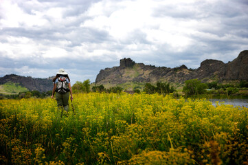 A woman walks along the Missouri River while out fly fishing.