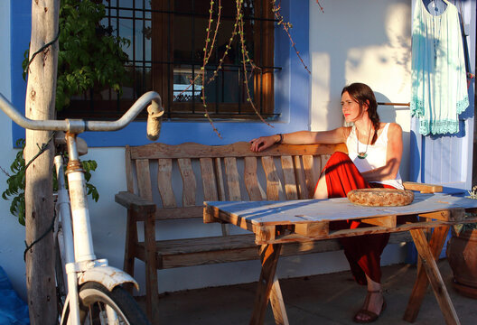 Young beautiful woman sits in the terrace of an stylish bar in Formentera, Balearic Islands, Spain.