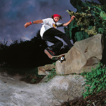 Skateboarder performs trick in natural environment