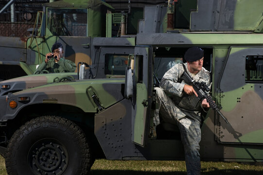 Military police officers secure tactical vehicles on base.