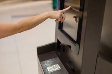 Faceless woman using touchscreen ATM. 