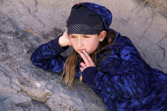 boy laying on rocks with a faraway look